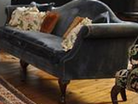 A grey couch with pillows on it.
